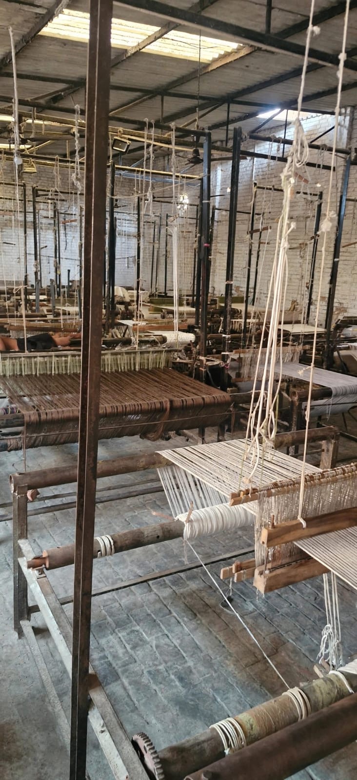 Traditional wooden looms at work in the weaving workshop