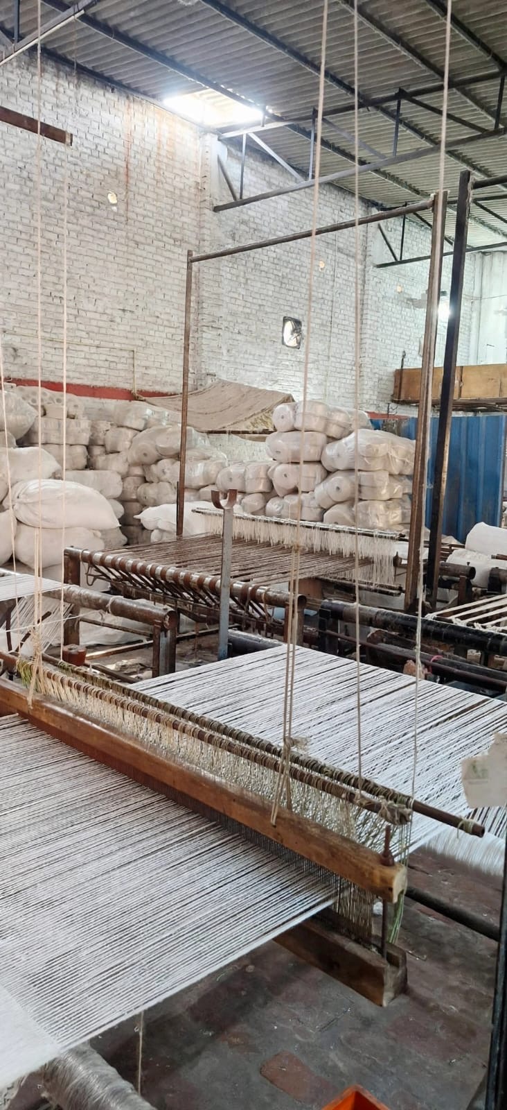 Traditional handloom weaving white yarn into cloth
