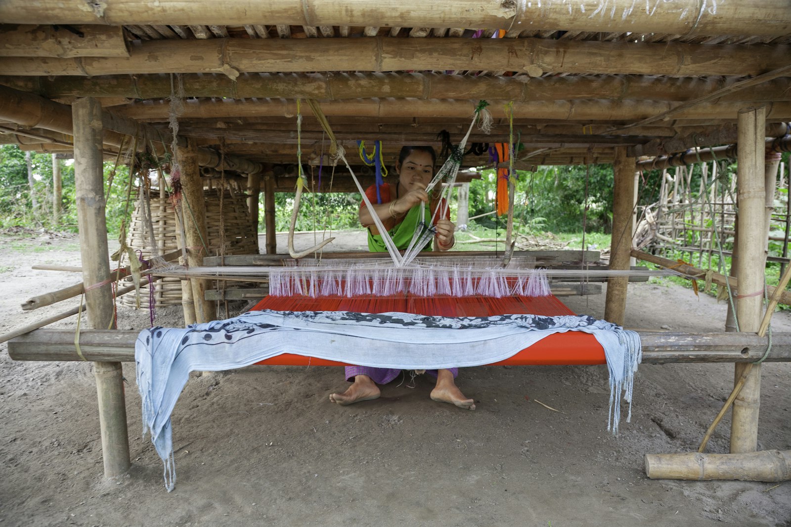 Artisan weaving a durrie on a traditional handloom